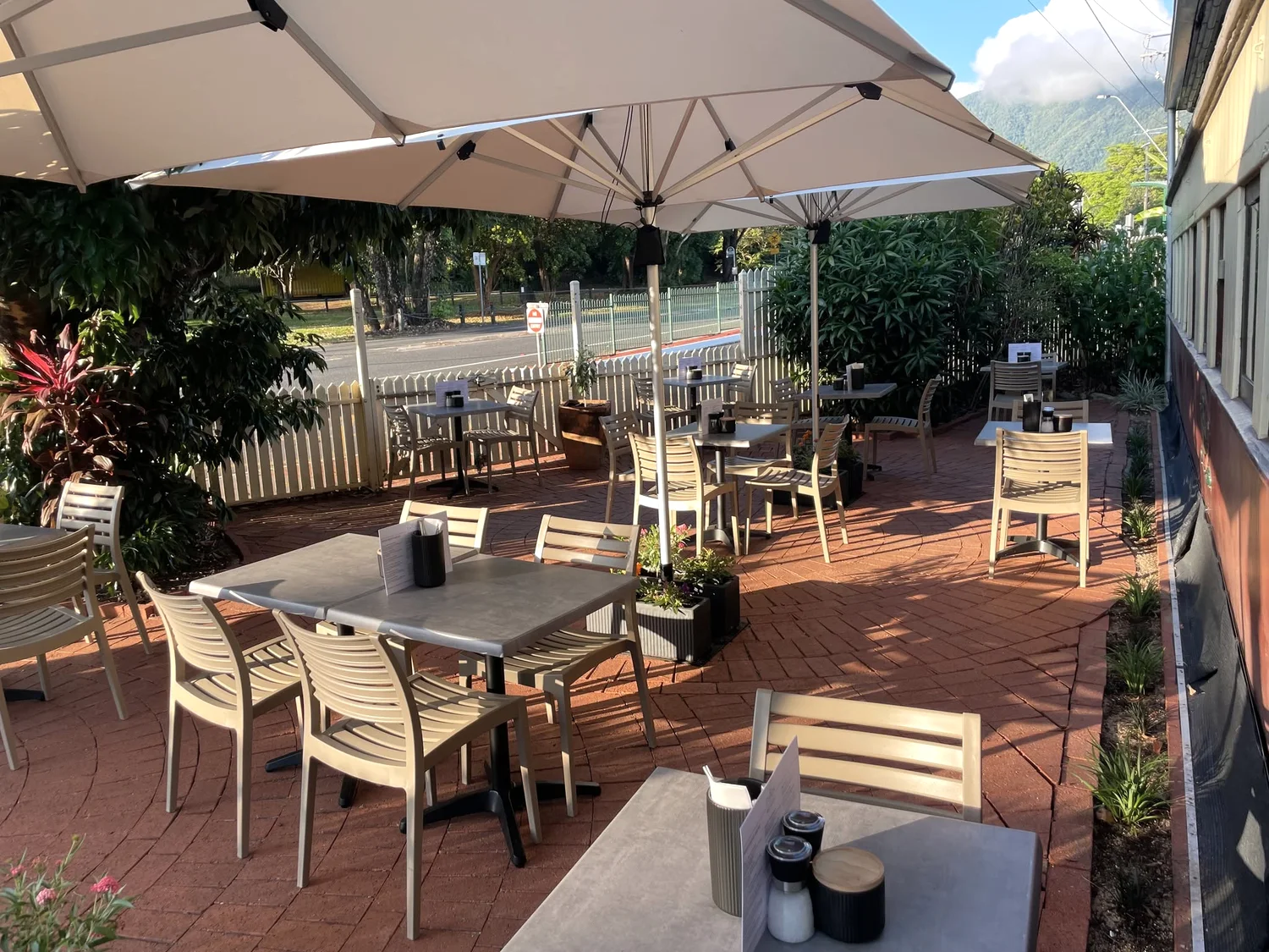Outdoor tables under umbrellas beside the railway carriage